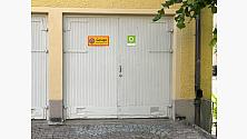 Dörren till källsorteringsrummet är märkt med en grön skylt med symbolen för återvinning.